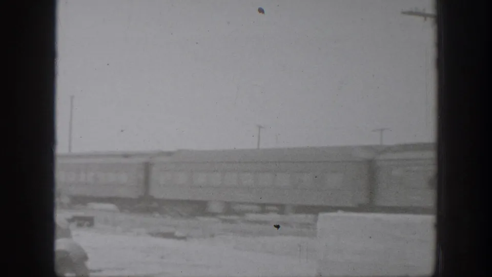Late-1930s California 8mm frame showing passenger rail cars passing through a soft, grainy trackside view.