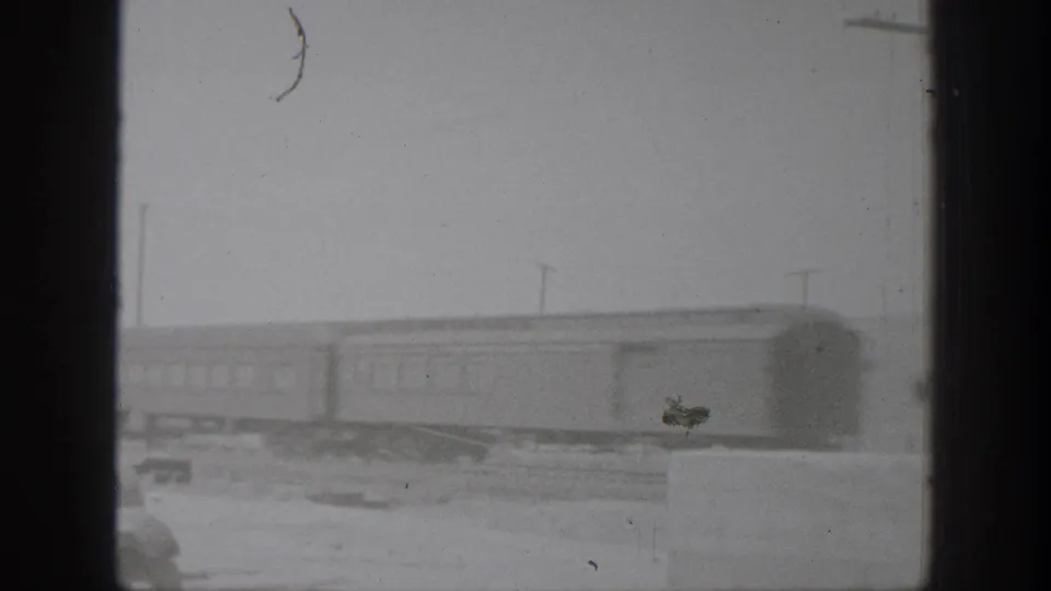 Black-and-white 1939 California 8mm frame showing a train on a dusty rural track through heavy window-like framing.