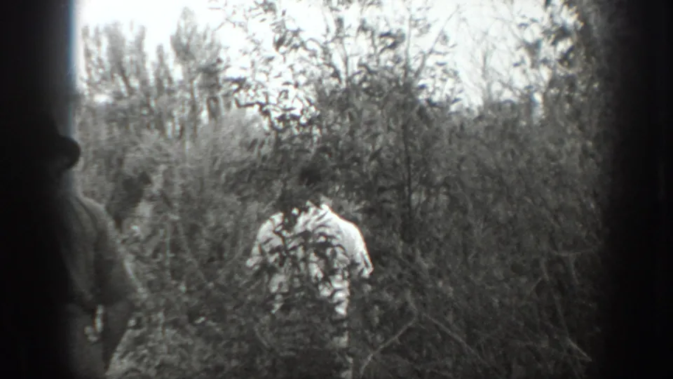 In 1939 California home-movie footage, adult men in light shirts and hats appear among dense shrubs and trees.