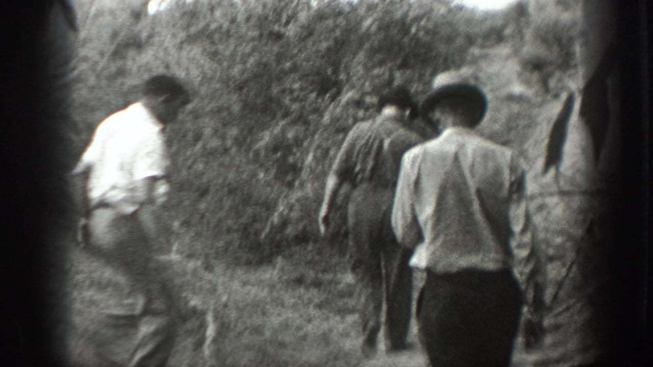 1939 California 8mm footage shows three men in light shirts and hats walking away on a brush-lined dirt path.