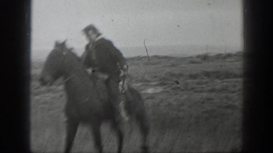 1939 Montana 8mm frame showing a man on horseback moving through a wide rural field.