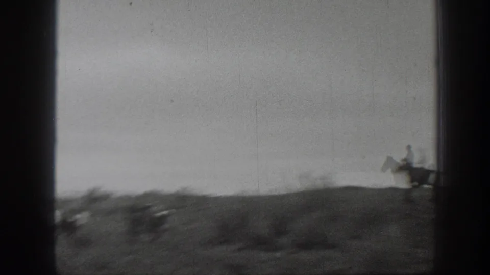 1939 Montana 8mm frame with a lone rider on horseback near the right edge of a low, brushy prairie horizon.