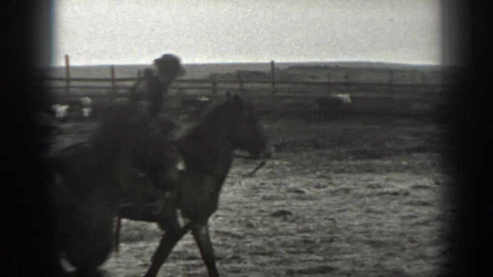 1939 Montana 8mm frame showing a man on horseback in a wooden corral, with open range visible beyond the fence.