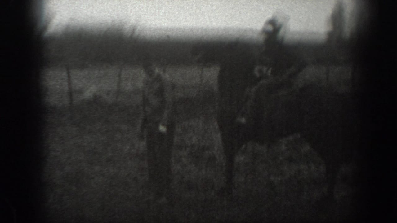 1939 Montana 8mm frame showing a man on horseback near fencing, with another figure and small animals in a rural field.