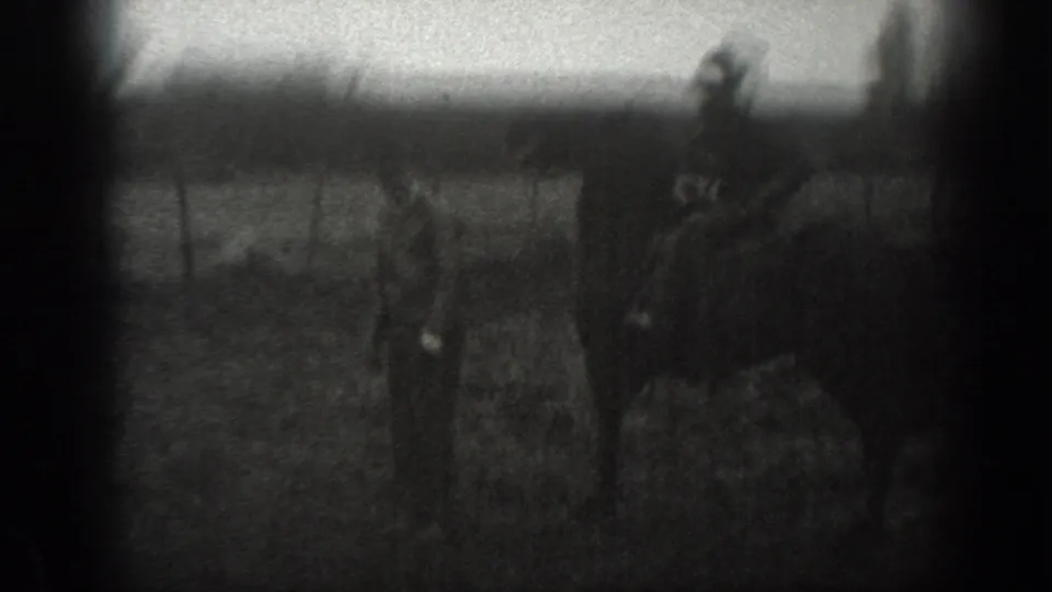 1939 Montana 8mm frame showing a man on horseback near fencing, with another figure and small animals in a rural field.