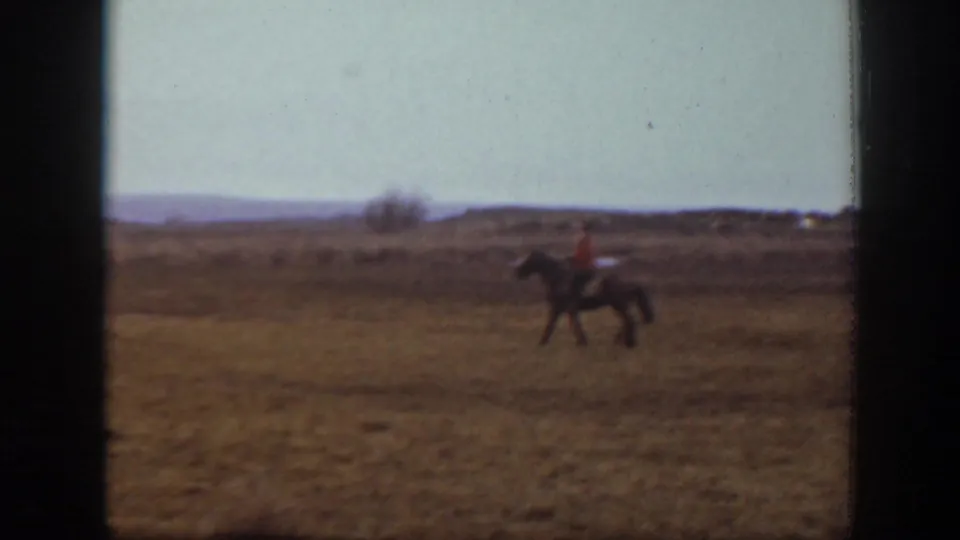The rider and horse appear small against a wide Montana pasture landscape in the supplied 1939 home-movie clip.