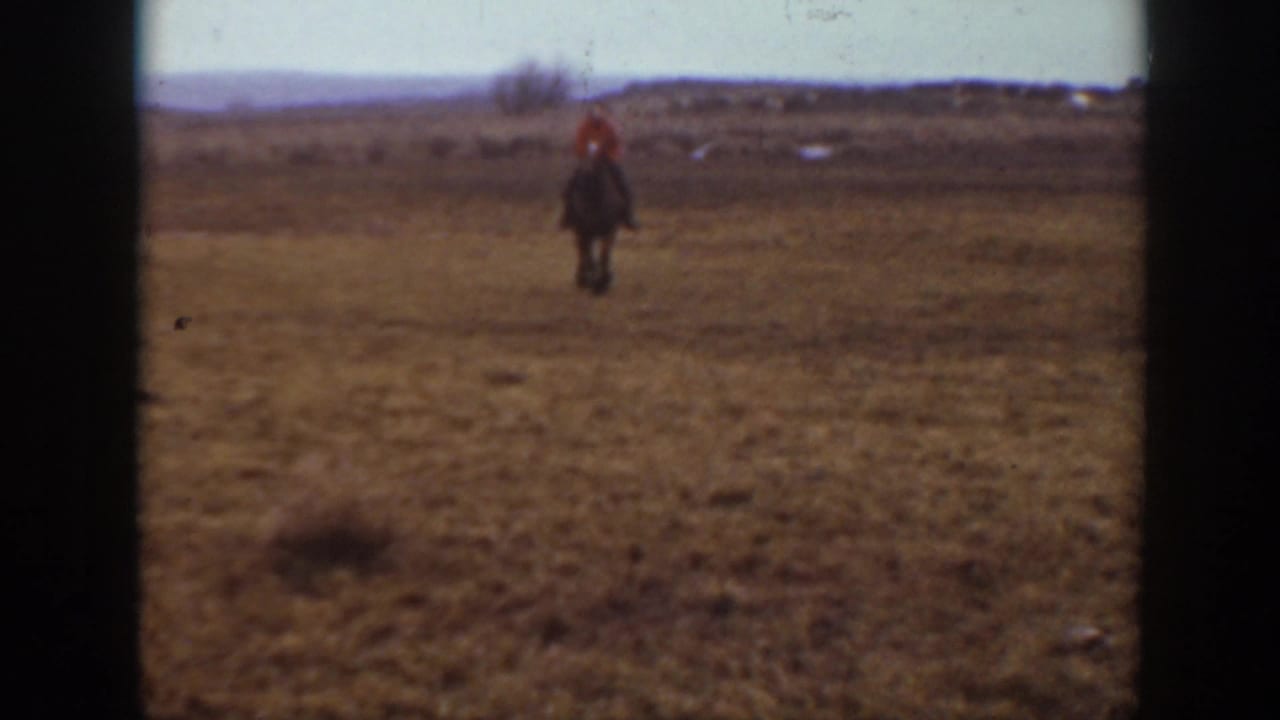 1939 Montana 8mm frame showing a distant horseback rider in open prairie with low hills on the horizon.