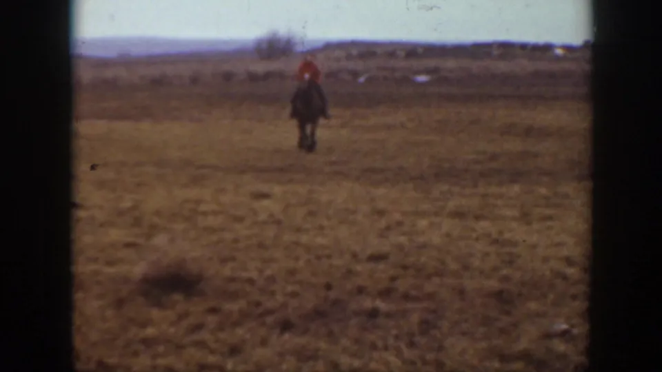 1939 Montana 8mm frame showing a distant horseback rider in open prairie with low hills on the horizon.