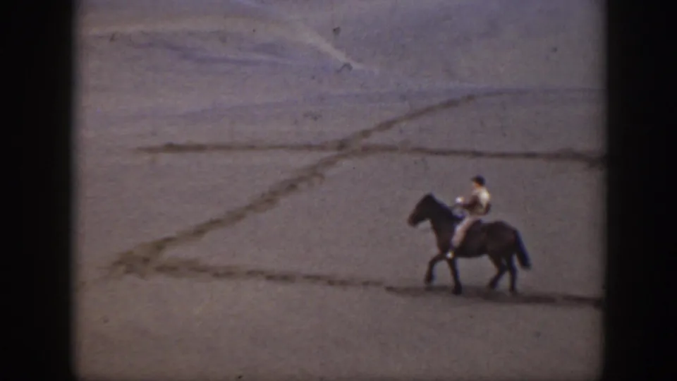 The final frame shows a lone horseback rider in the 1939 Montana dunes, framed by faded color and grainy 8mm texture.