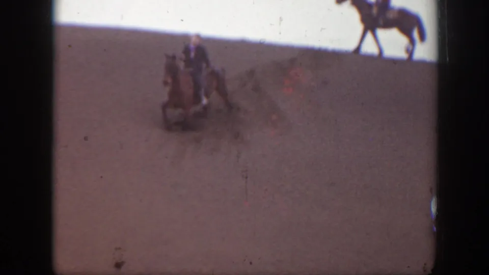 1939 Montana 8mm frame showing riders on horseback at a distance across a dry, open landscape with visible film edge marks.