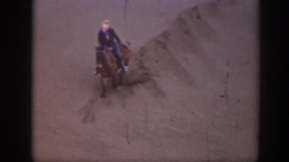 1939 Montana 8mm frame showing a rider facing the camera on horseback, surrounded by dry terrain and home-movie film marks.