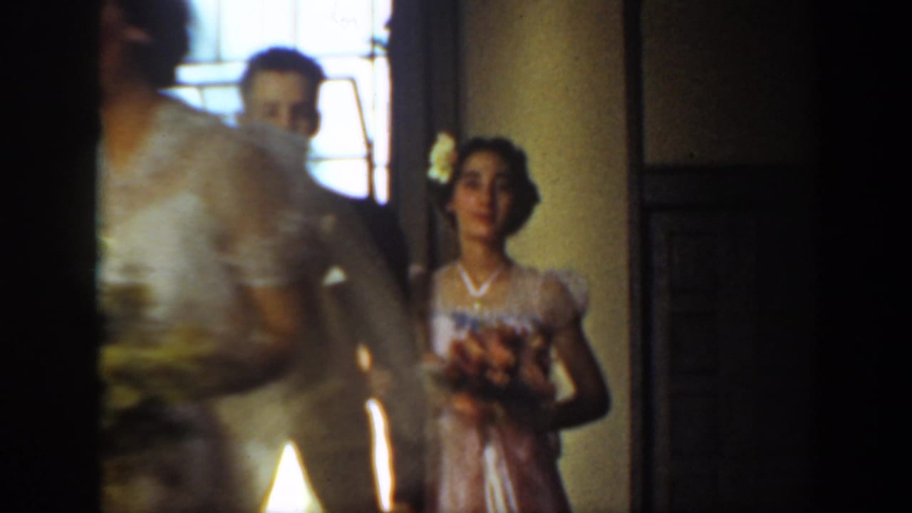 Wedding party members pass through a softly lit interior aisle.