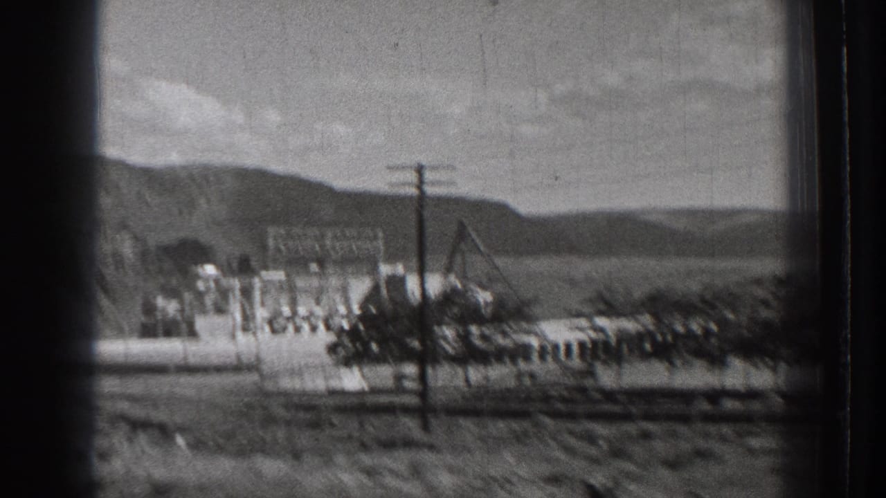 1939 Washington view of the Rock Island Dam area appears to show electrical framework, utility poles, industrial buildings, and dry hills.