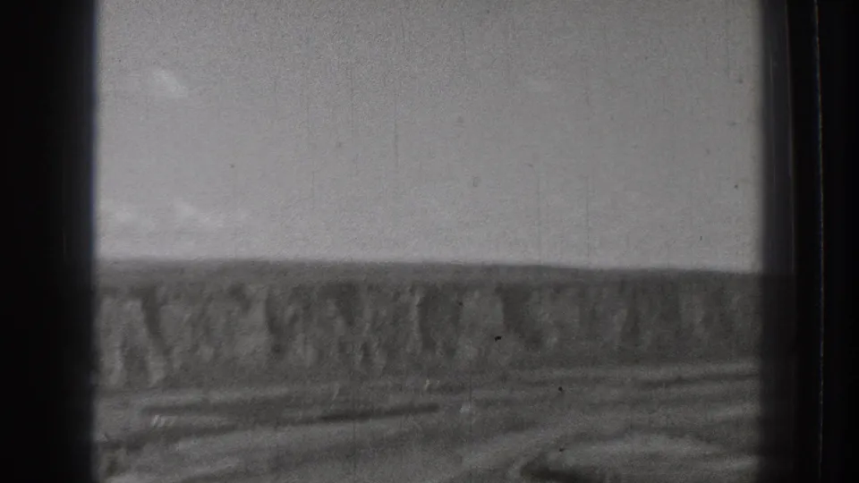 Black-and-white 1939 8mm view of a rugged open landscape in Washington, with distant cliffs and a broad channel or riverbed.