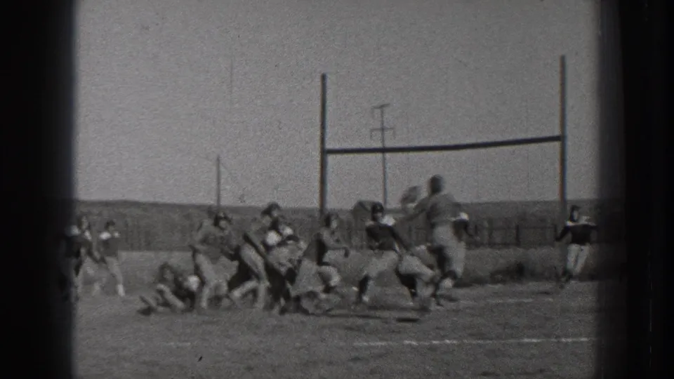 1939 Washington 8mm frame showing football players clustered near goalposts during a tackle on an open field.