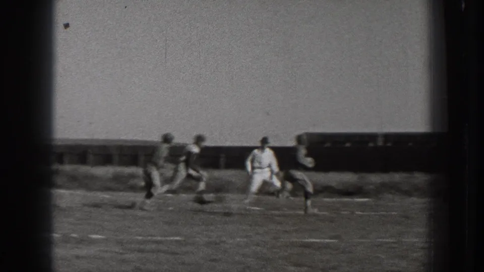 1939 Washington home-movie frame with football players running across the field as the play moves away from the goal area.