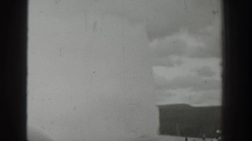 1939 Wyoming home-movie view of a water or steam plume with small spectators at the base, framed by dark vertical edges.