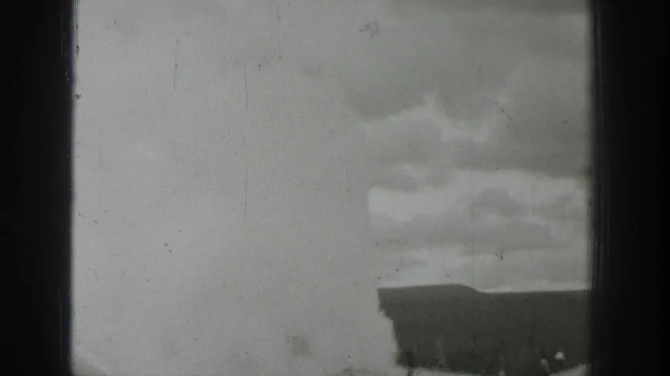 1939 Wyoming 8mm frame showing overcast sky, film gate edges, and the top of a town building entering the lower view.