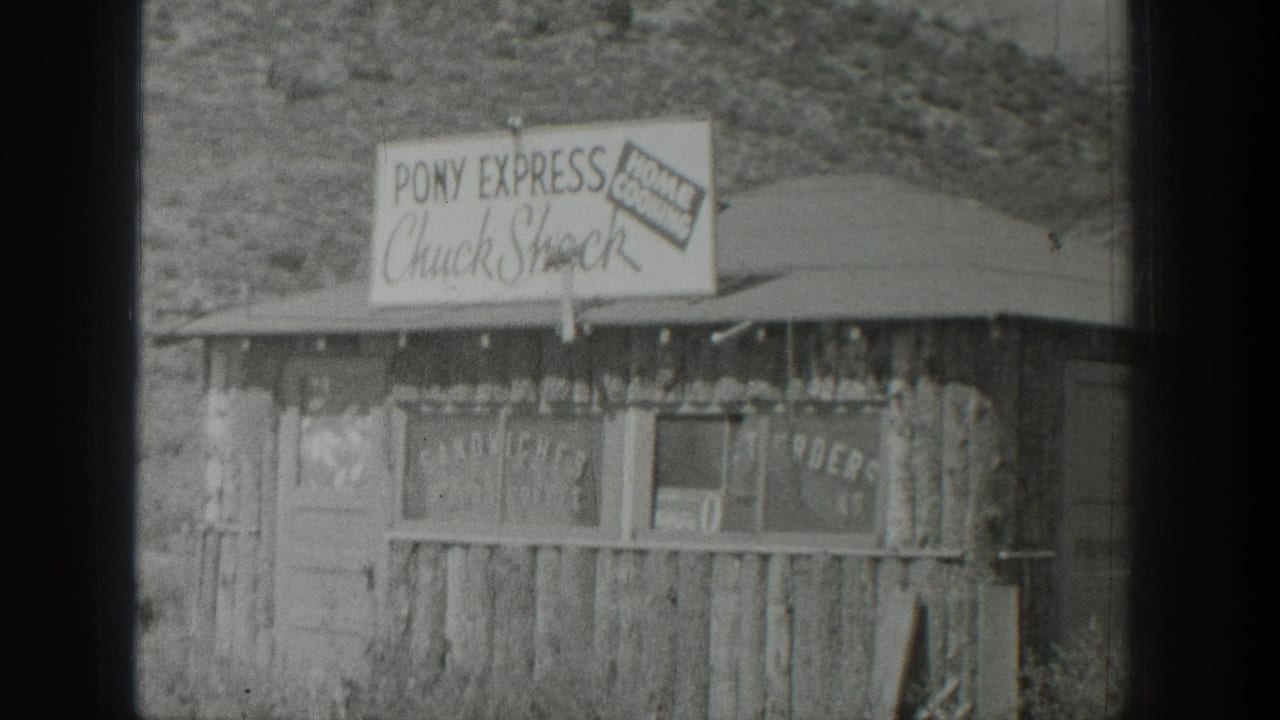 1939 Wyoming 8mm frame showing a weathered roadside food stand with Pony Express Chuck Shack signage and hillside behind it.