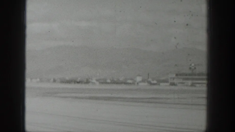 The runway and airport structures remain in view after the aircraft has moved out of frame, with Wyoming mountains beyond.