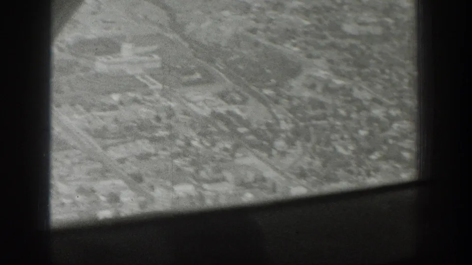 1939 Wyoming airplane-window view over a small settlement or tree-lined area, partly obscured by the aircraft interior framing.