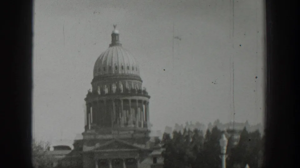 1939 Wyoming footage appears to show a domed public building or capitol-like structure behind trees, with soft focus and scratches.