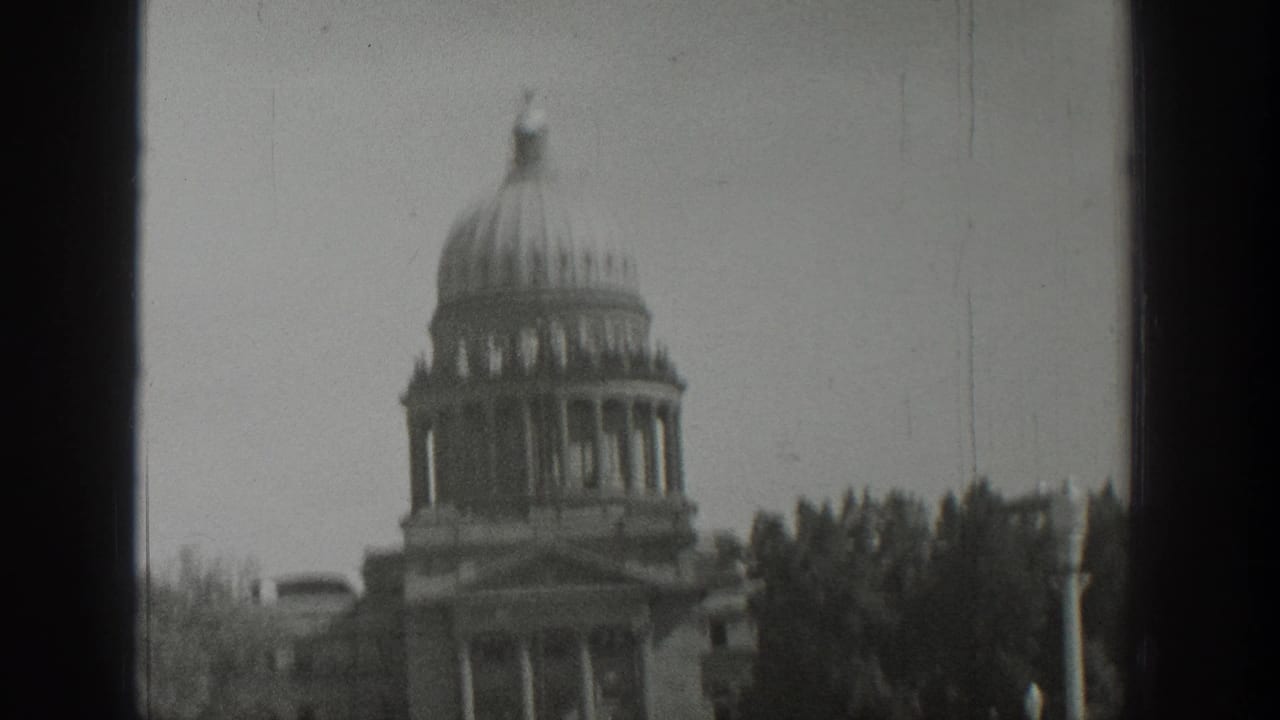 1939 Wyoming 8mm frame showing a domed civic building with columns, trees, and a dark vertical window frame.