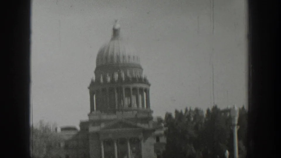 1939 Wyoming 8mm frame showing a domed civic building with columns, trees, and a dark vertical window frame.