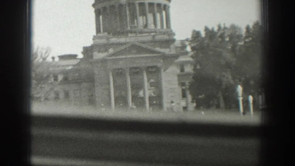 1939 Wyoming 8mm frame showing the columned facade of a domed civic building behind a window sill and dark frame edge.