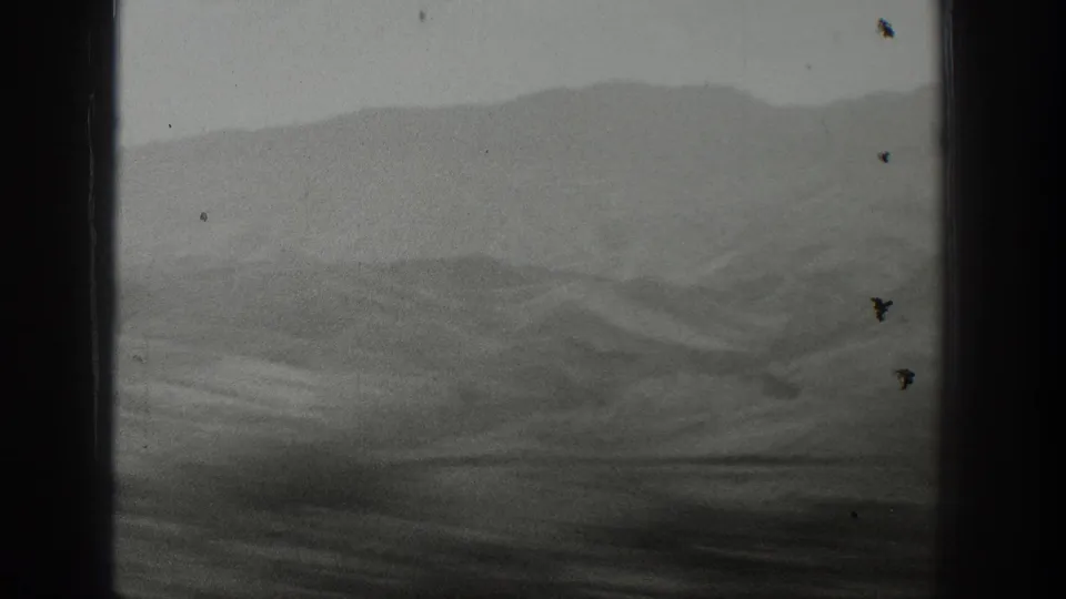The final frame shows hazy Wyoming mountain ridges and darker foreground terrain through a vehicle window opening.