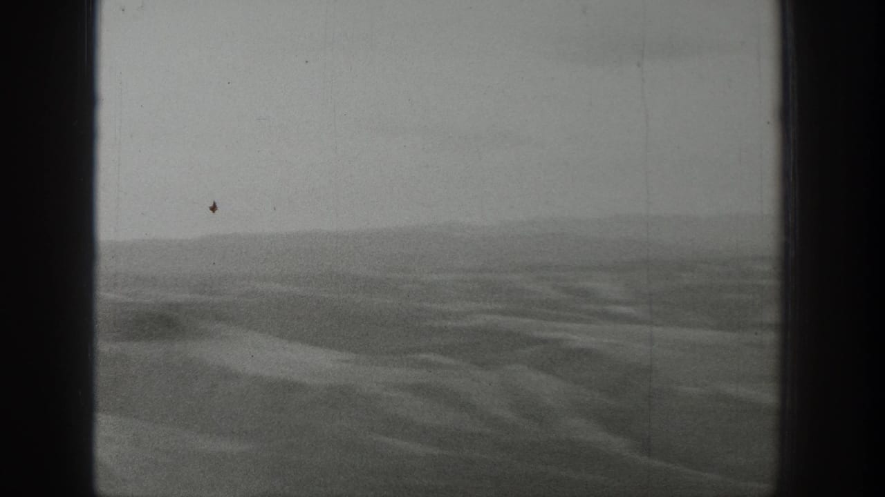 1939 Wyoming 8mm home-movie frame showing hazy open desert terrain, low hills, and dark film gate edges.