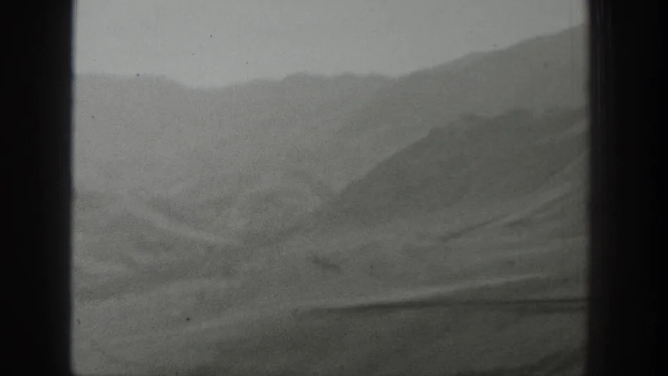 Rolling Wyoming hills and ridges pass behind a central window frame in grainy 1939 home-movie footage.