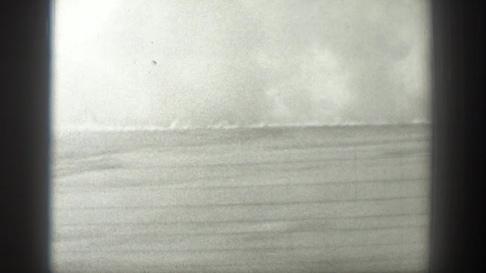 Black-and-white travel frame with bright water, a low horizon, and dark window edges in the supplied 1939 Wyoming clip.