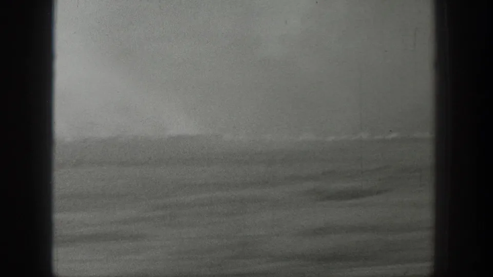 Hazy black-and-white view of open water and sky behind a dark central window bar, from 1939 Wyoming home-movie footage.