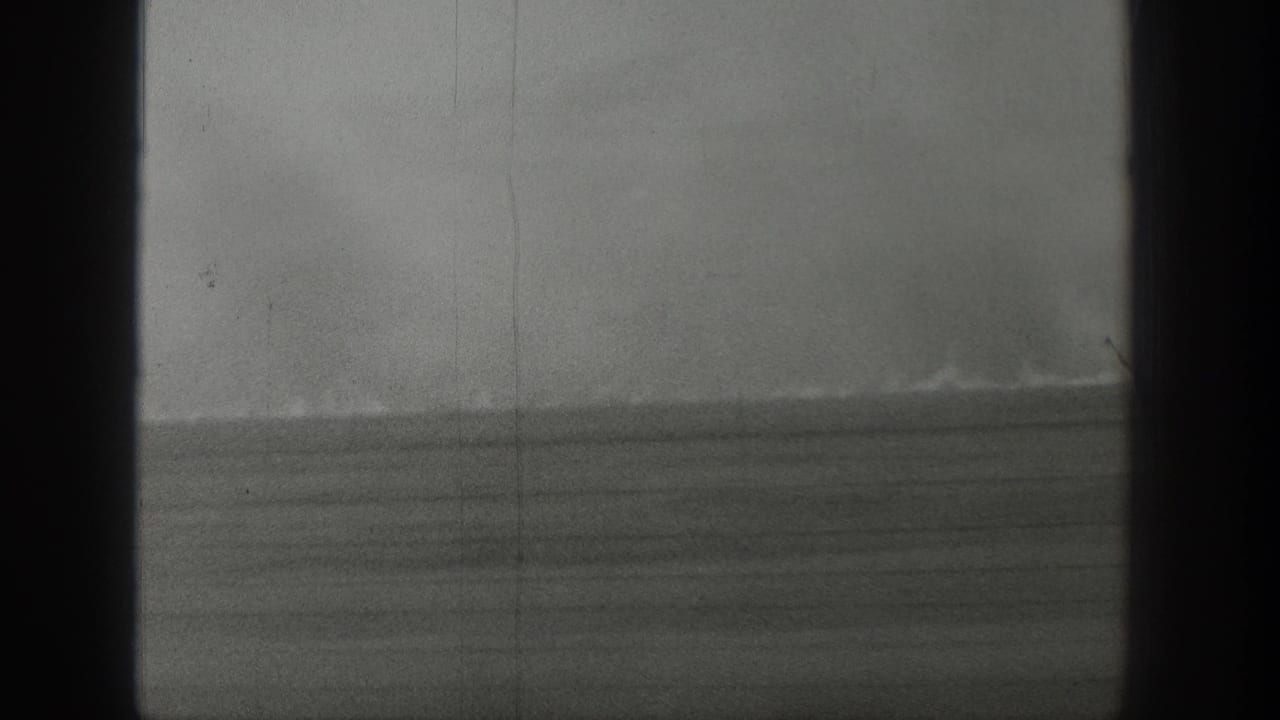 1939 Wyoming 8mm frame showing distant smoke over an open grassland horizon with dark gate borders and visible film grain.