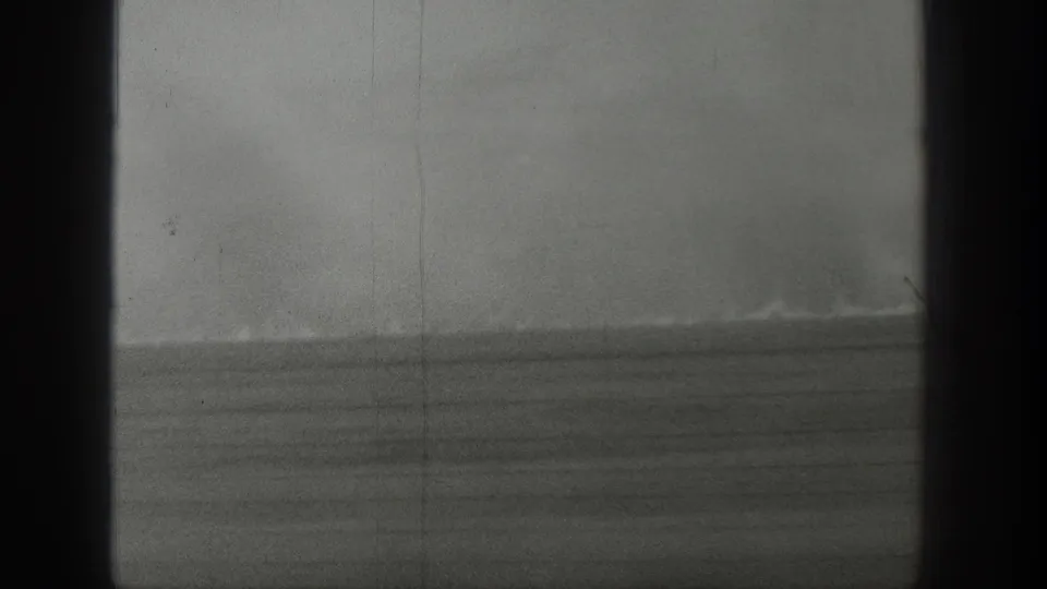1939 Wyoming 8mm frame showing distant smoke over an open grassland horizon with dark gate borders and visible film grain.