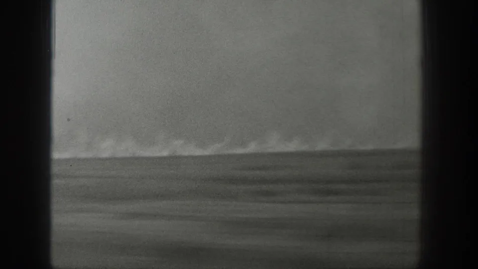 1939 Wyoming 8mm frame showing heavier smoke spreading above a low grassland burn line, with grain and scratches visible.