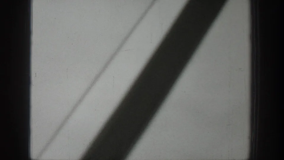1939 Wyoming 8mm frame showing a pale window or interior panel crossed by a dark diagonal shadow from inside a moving bus.