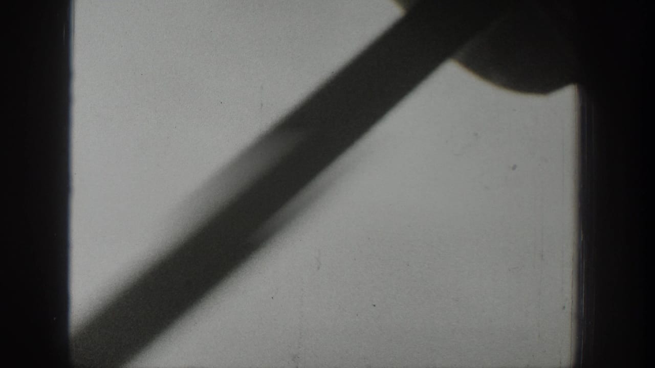 Dark vertical bus-window bar with a diagonal shadow on pale glass.