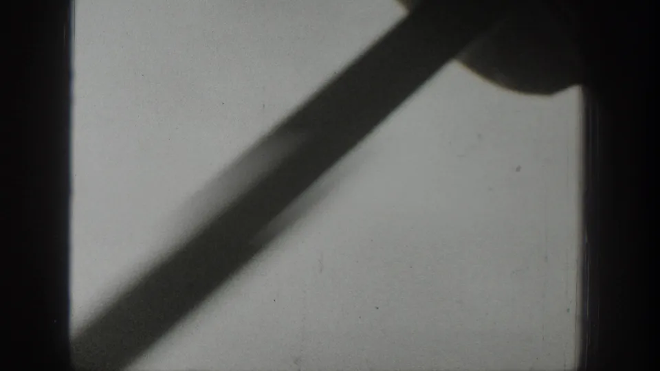 1939 Wyoming travel frame with a dark vertical window bar and diagonal shadow against a pale, softly exposed surface.
