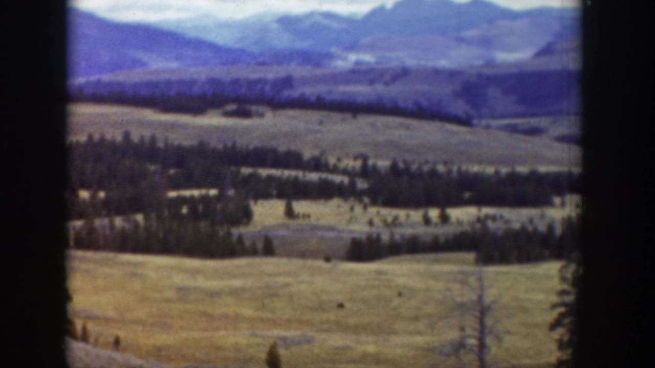 1939 Wyoming 8mm frame showing open grassland, tree lines, and distant mountains with dark film-frame edges.