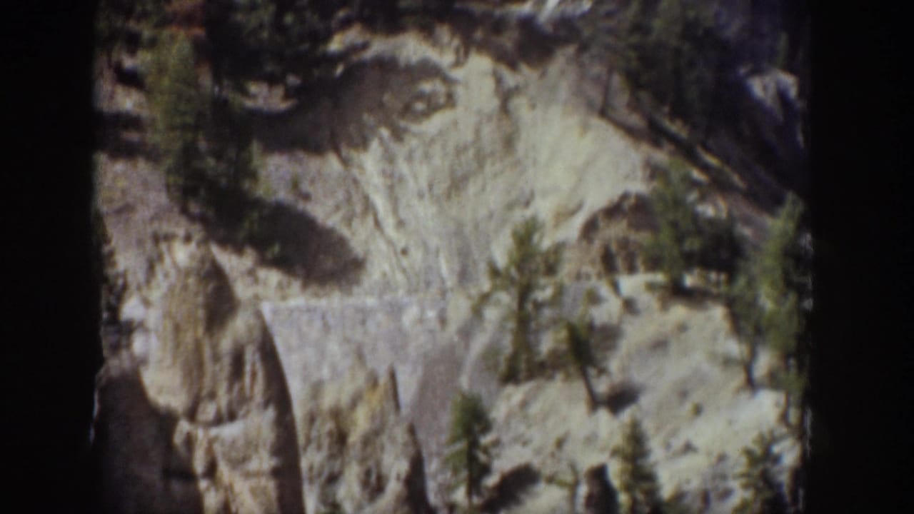 1939 Wyoming 8mm frame showing a pale rocky cliff and small conifers before the waterfall comes into view.