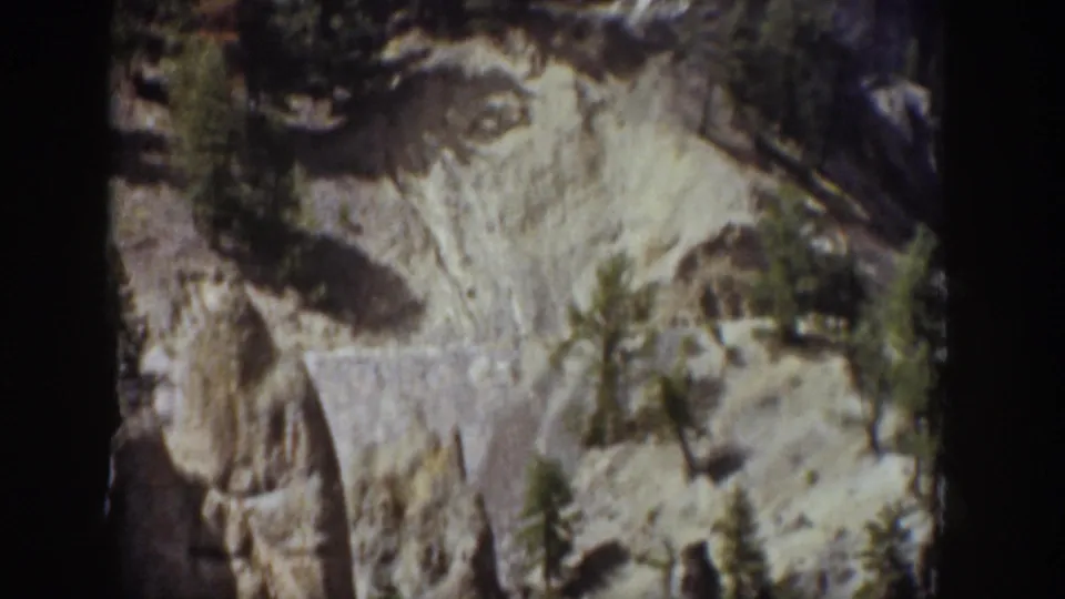 1939 Wyoming 8mm frame showing a pale rocky cliff and small conifers before the waterfall comes into view.