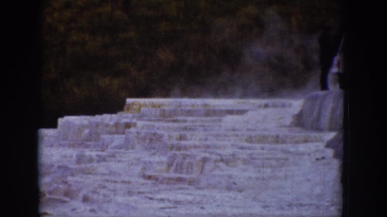 Terraced steaming formation with a distant person near the right edge of the frame.