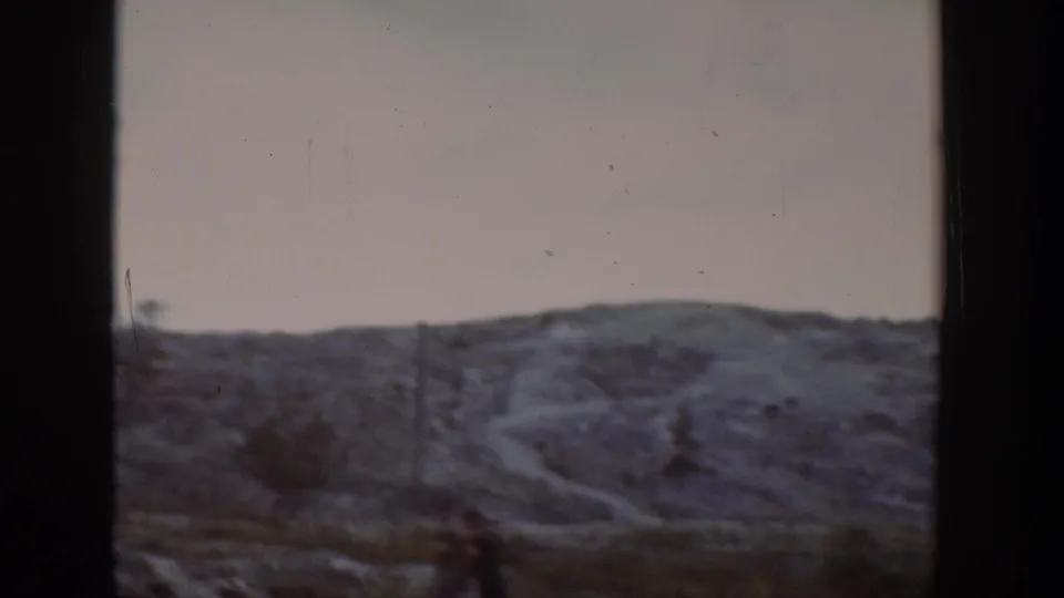 1939 Wyoming home-movie view of a low ridge with a faint dirt path or road crossing the scrubby slope.