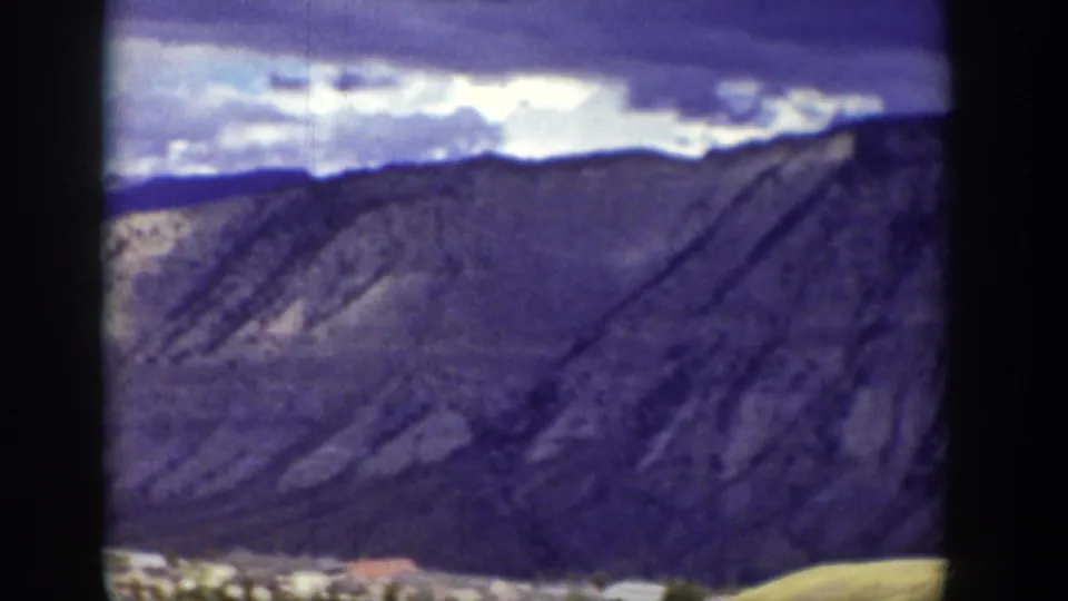 A closer 1939 Wyoming frame centers on rugged mountain slopes, with the lower edge showing part of the valley settlement.