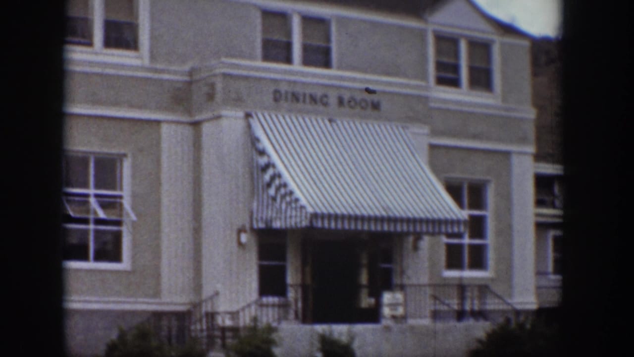 Dining-room building exterior with striped awning and multiple windows.