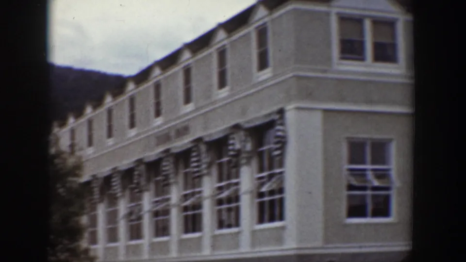 1939 Wyoming home-movie view of a long dining-room or lodge-like building with repeated windows and striped awnings.