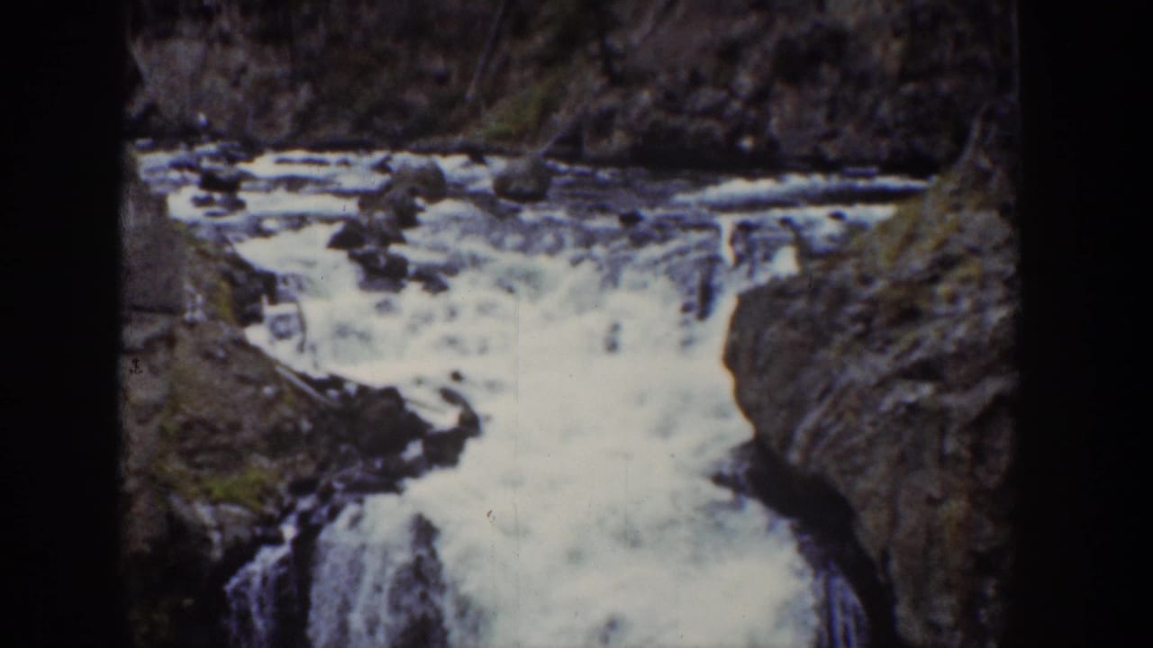 1939 Wyoming 8mm frame showing whitewater cascading between dark rocks in a mountain canyon.
