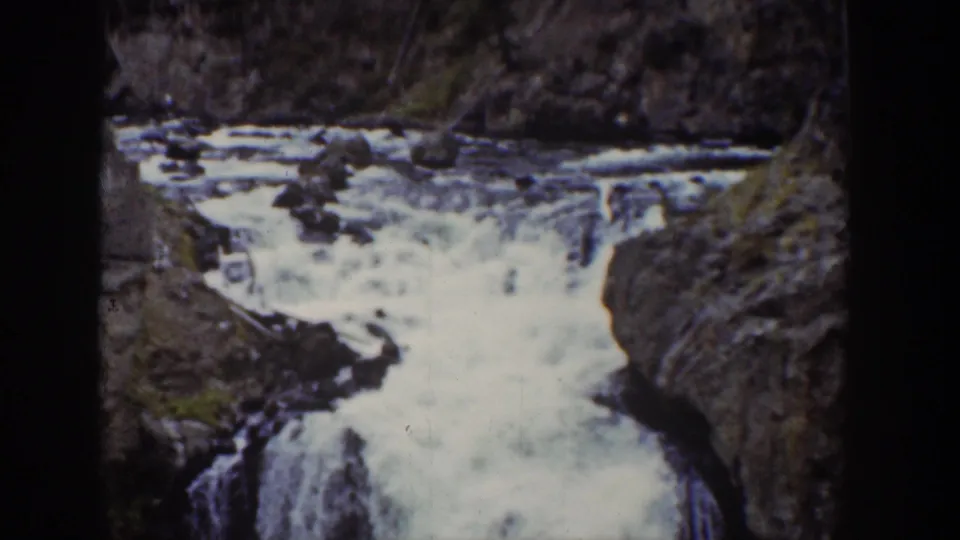 1939 Wyoming 8mm frame showing whitewater cascading between dark rocks in a mountain canyon.